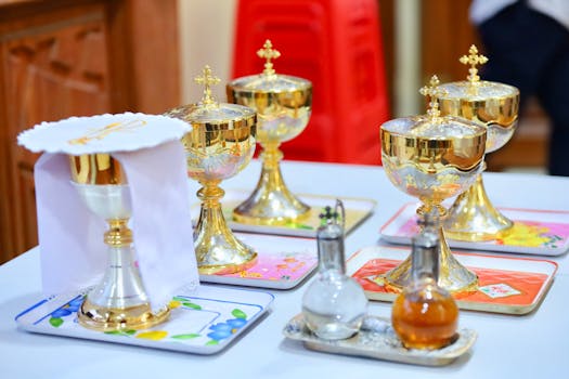 Beautiful gold chalices and communion vessels arranged for a religious ceremony indoors.